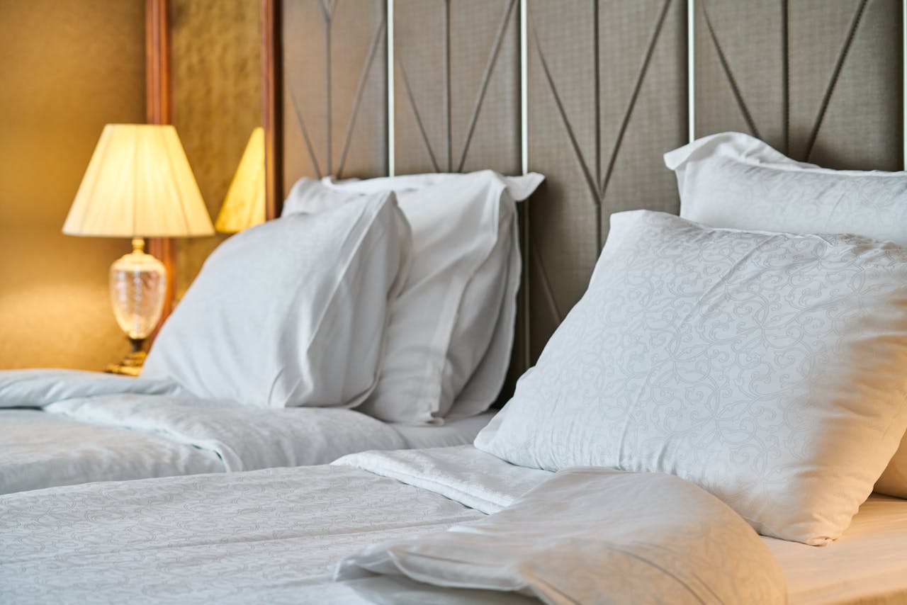 Inviting hotel room with comfortable bedding and ambient lighting, perfect for relaxation and luxury stay.