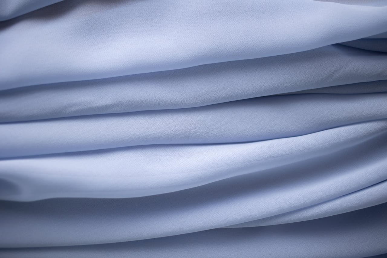 Close-up of light blue fabric folds creating a delicate flowing texture.